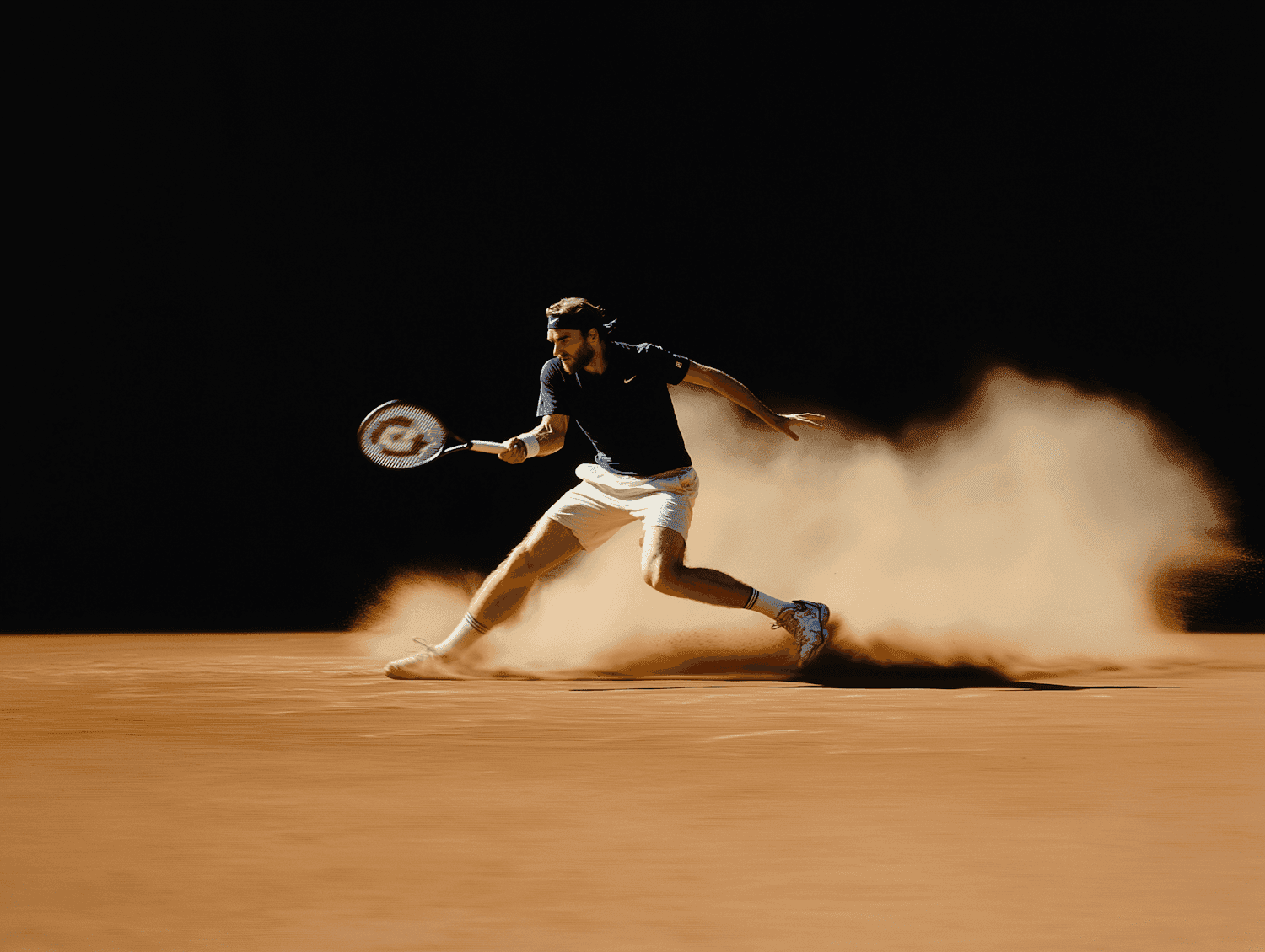 Tennis player sliding across a clay court in a cloud of dust against a black background
